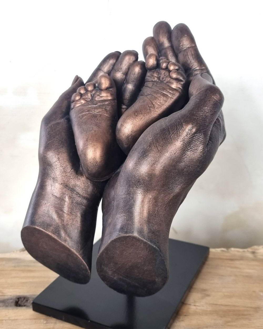 Handbeeld van de ouders, samen met de voetjes van hun baby, in brons, gemaakt door Bodycasting Nederland