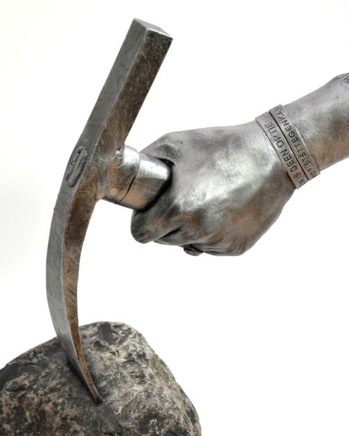 Bodycasting handbeeld met pikhouweel als symbool voor vakmanschap en veerkracht