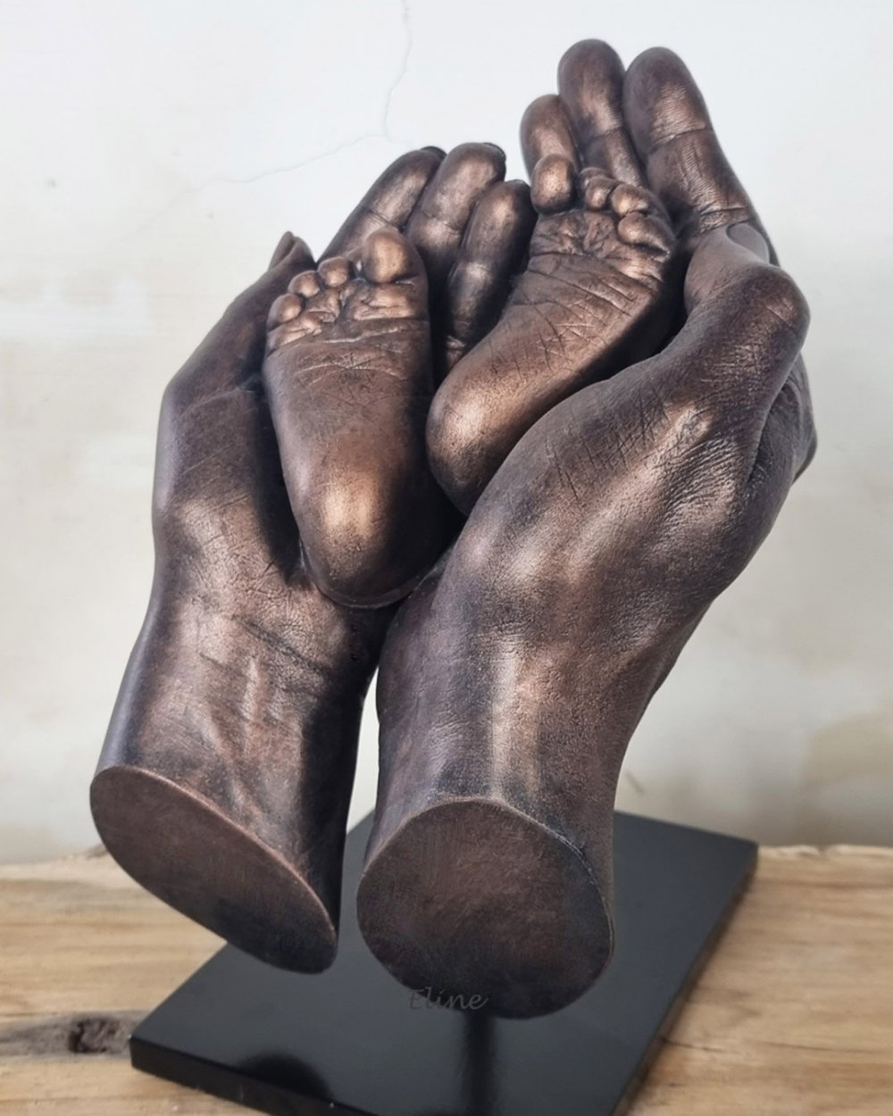 Handbeeld van de ouders, samen met de voetjes van hun baby, in brons, gemaakt door Bodycasting Nederland