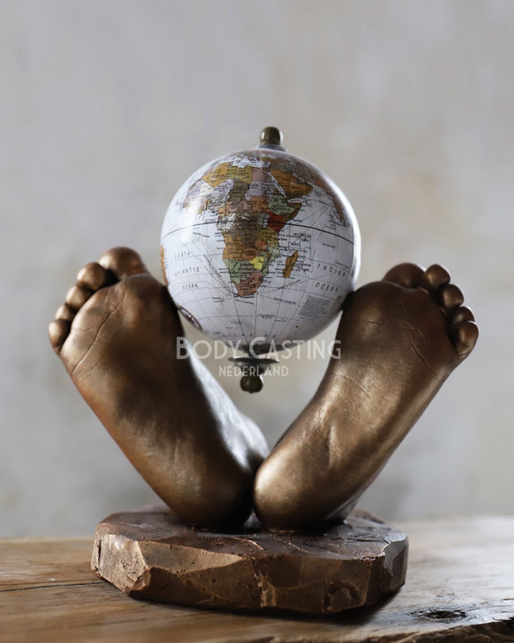 Twee voetjes als beeld met een wereldbol ertussen, gemaakt door Bodycasting Nederland