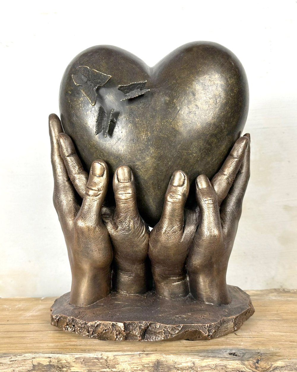 Bodycasting handbeeld met hartvormige urn met vlinders gedragen door vier handen