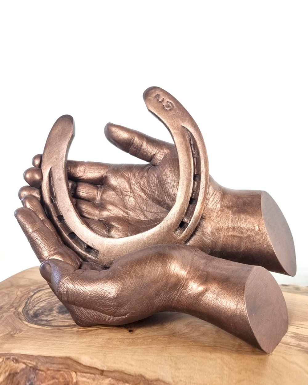 Twee handen die een hoefijzer dragen, bodycasting handbeeld in brons