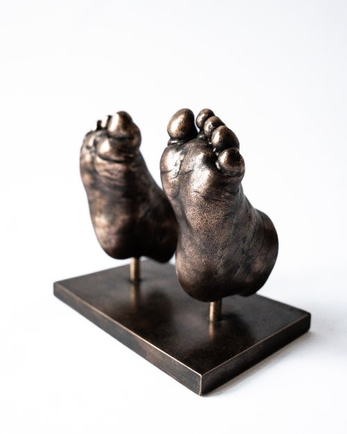 Bronzen babyvoetjes op metalen voetplaat gemaakt met bodycasting techniek