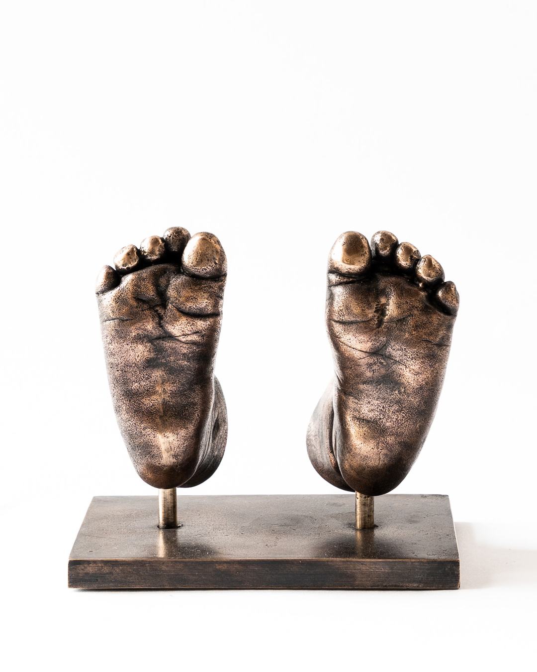 Bronzen babyvoetjes op metalen voetplaat gemaakt met bodycasting techniek