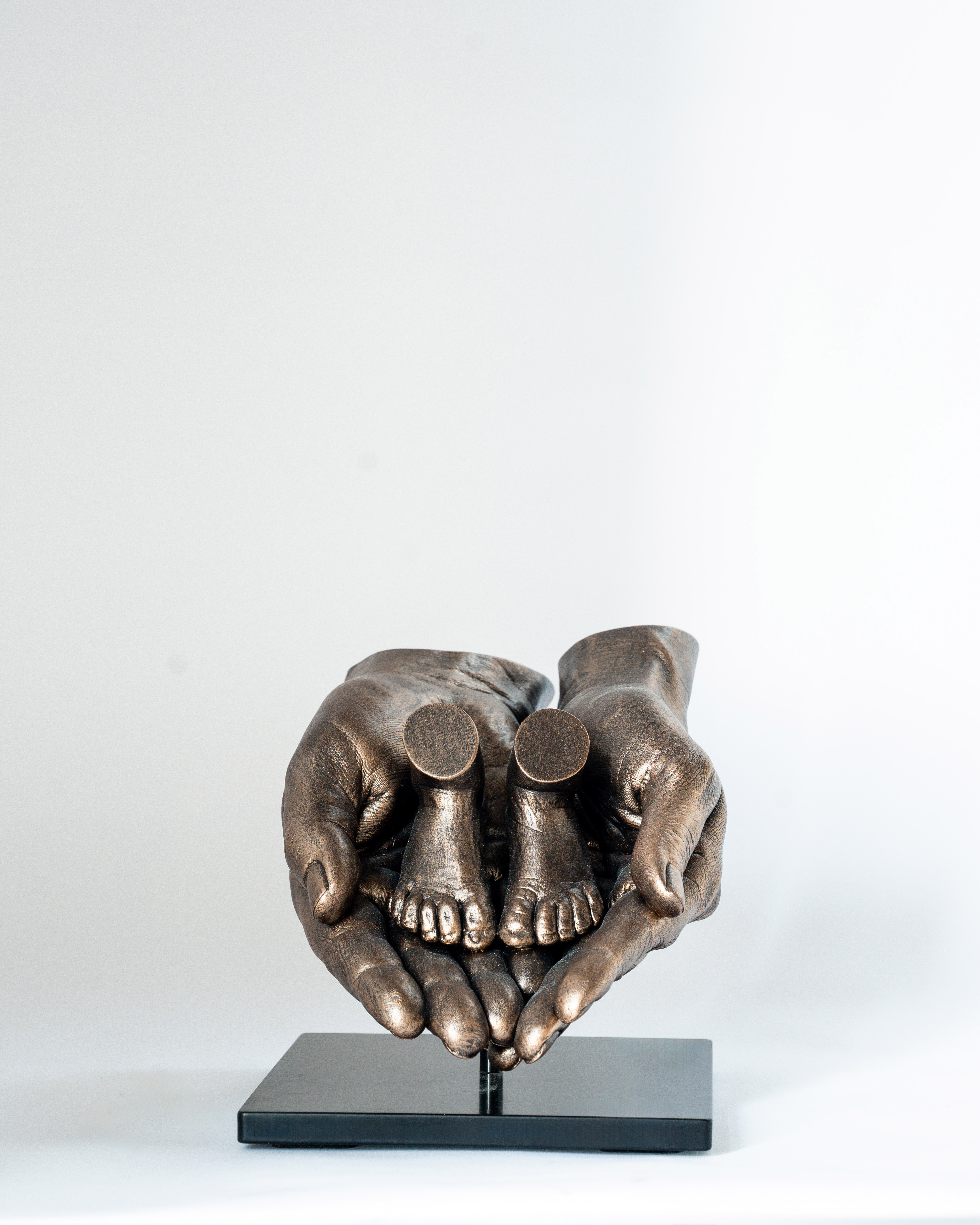 Bodycasting van babyvoetjes gedragen door ouderlijke handen