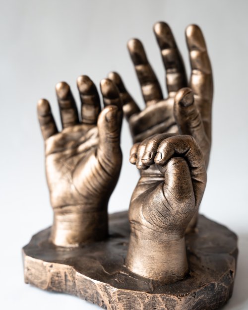Bodycasting van handafdrukken van drie kinderen in familiebeeld