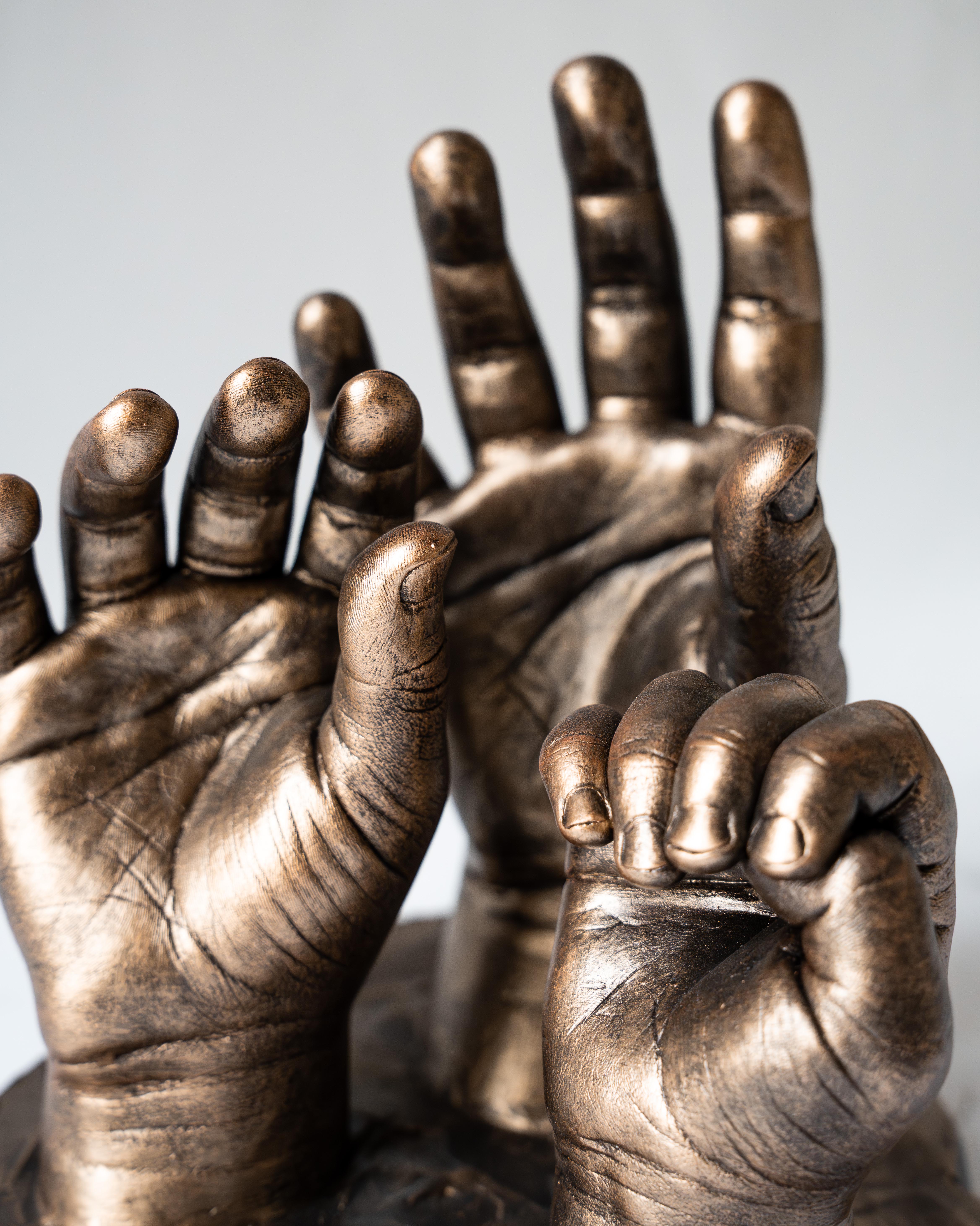 Bodycasting van handafdrukken van drie kinderen in familiebeeld