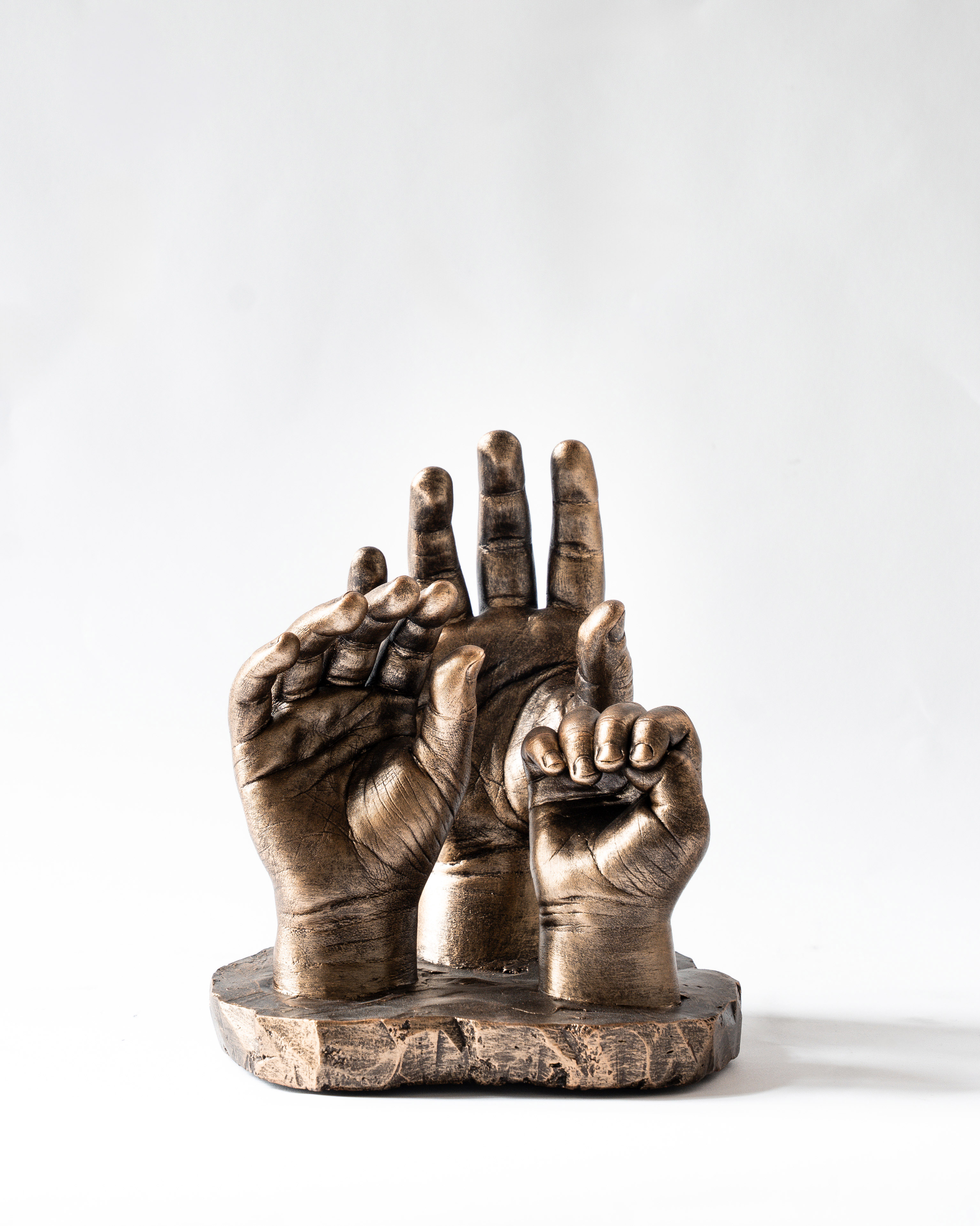 Bodycasting van handafdrukken van drie kinderen in familiebeeld