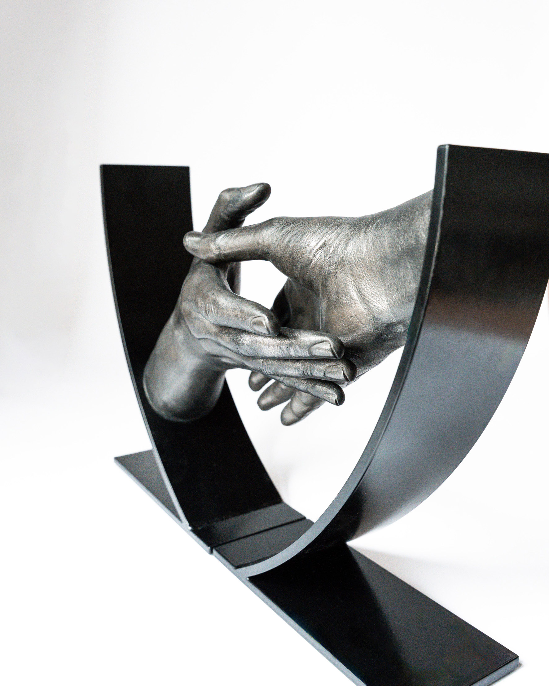 Handbeeld van twee handen die naar elkaar toe bewegen in metalen frame