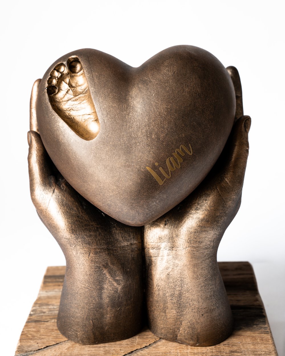 bodycasting handbeeld met urn hart en afdruk van babyvoetje in de urn