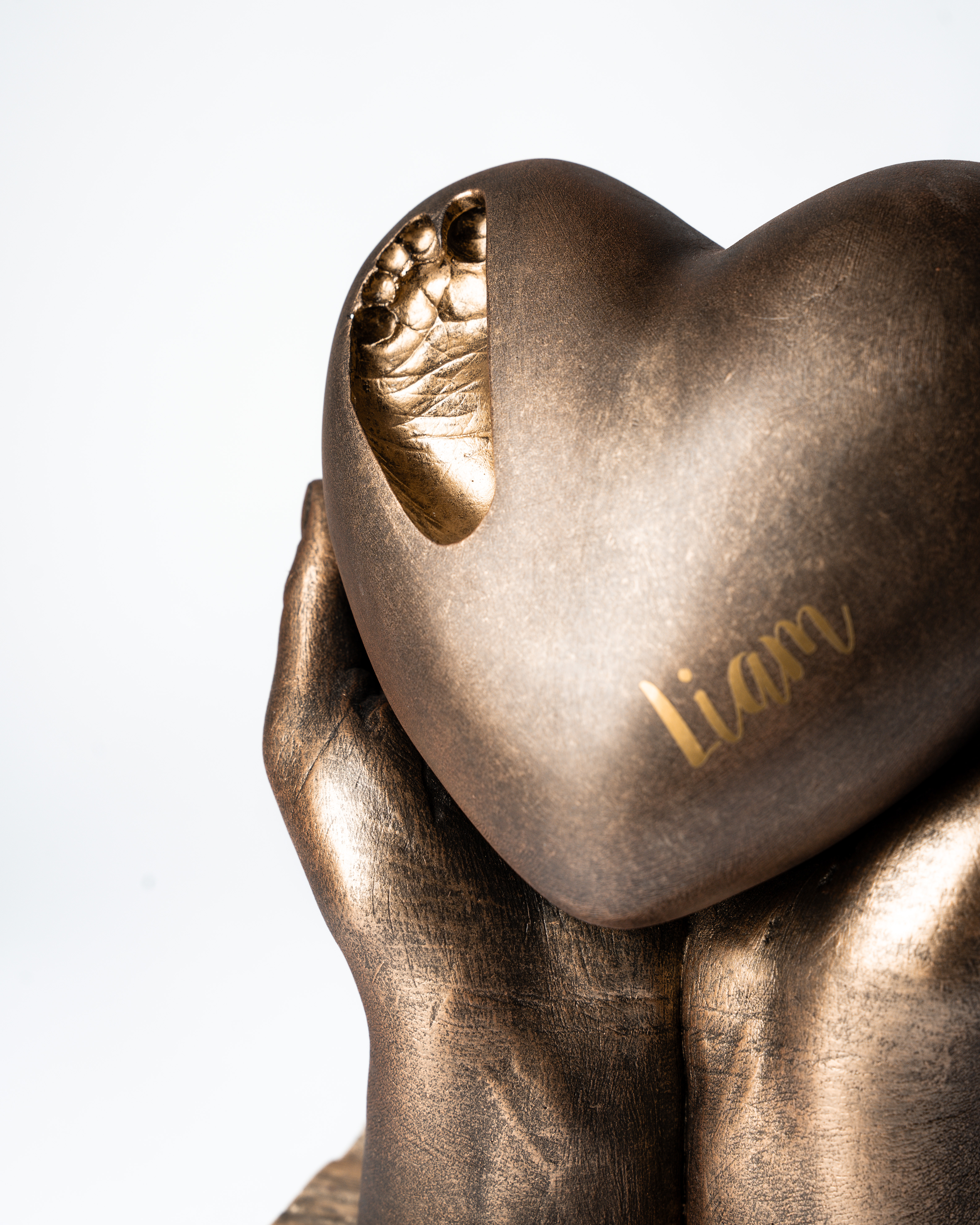 bodycasting handbeeld met urn hart en afdruk van babyvoetje in de urn